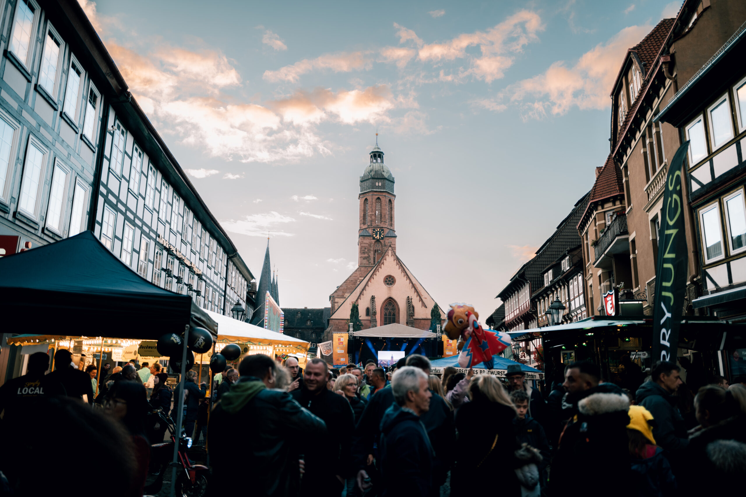 Mit Menschen gefüllter Markplaltz in Einbeck. Mit Sicht auf den Turm der Einbecker Marktkirche.