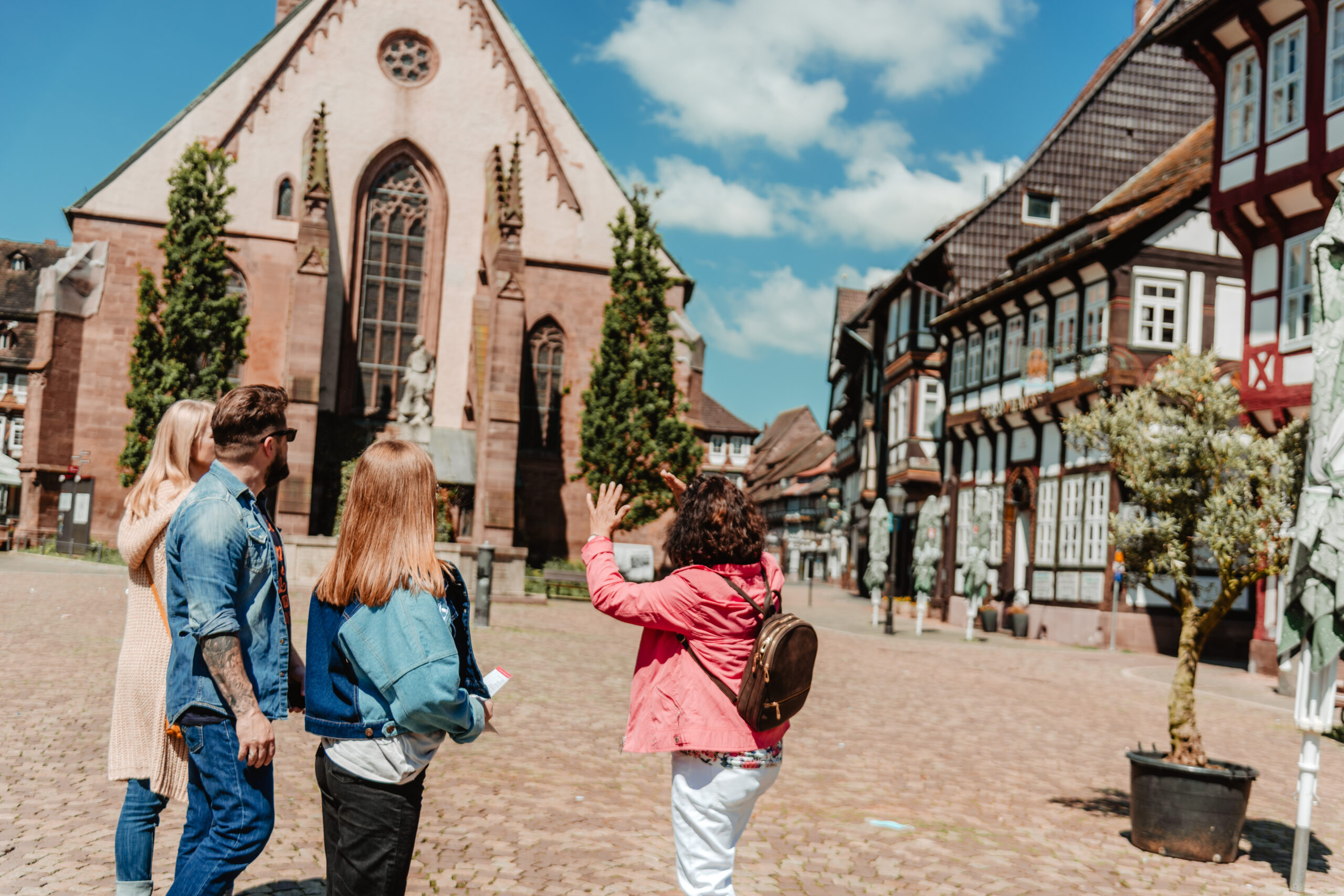 Eine Stadtführerin während einer Führung durch Einbeck mit Gästen auf dem historischen Marktplatz.
